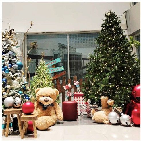 Osos de peluche y árboles navideños en lobby corporativo